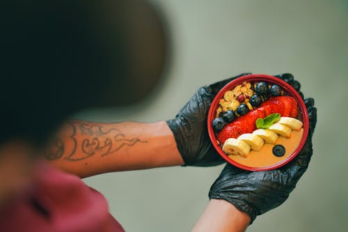 Free Close-up of a Man Holding a Smoothie Bowl Topped with Fruit Stock Photo