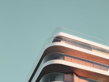 Minimalist photo of a sleek, modern building with curved balconies against a clear sky.