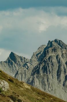 Dramatic view of rugged rocky mountain peaks with clouds above, capturing the natural beauty of the landscape.