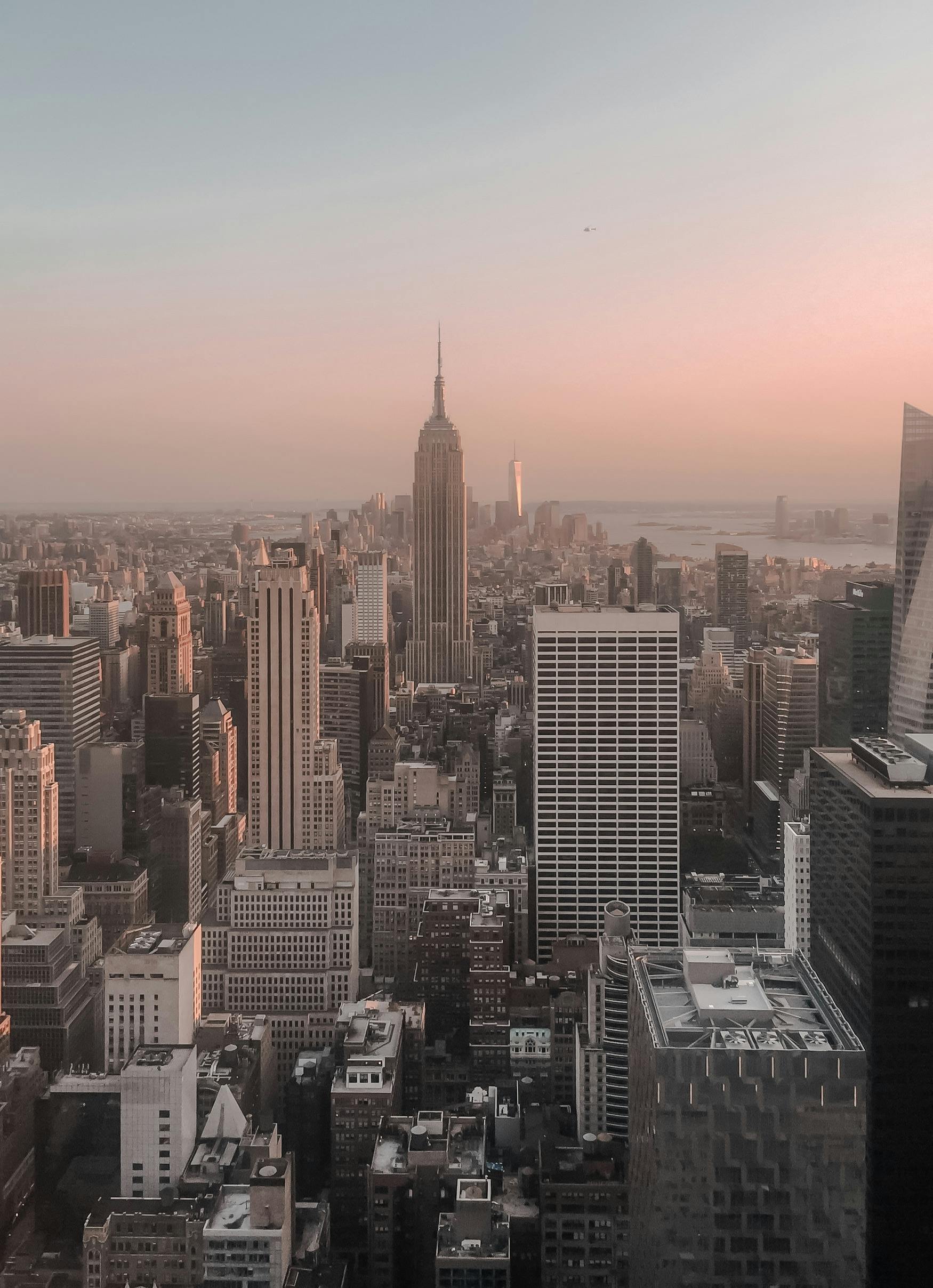 Stunning aerial view of Manhattan skyline at sunset featuring the Empire State Building and skyscrapers.