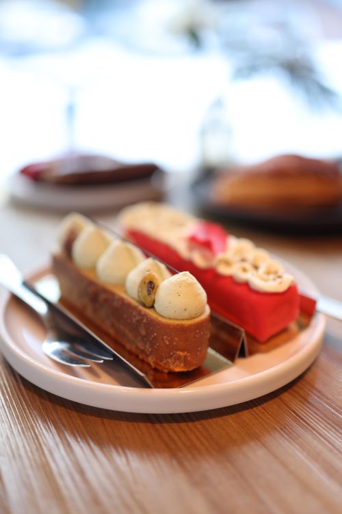 Free Close-up of elegant eclairs on a white plate, showcasing rich frosting and decorative touches. Stock Photo