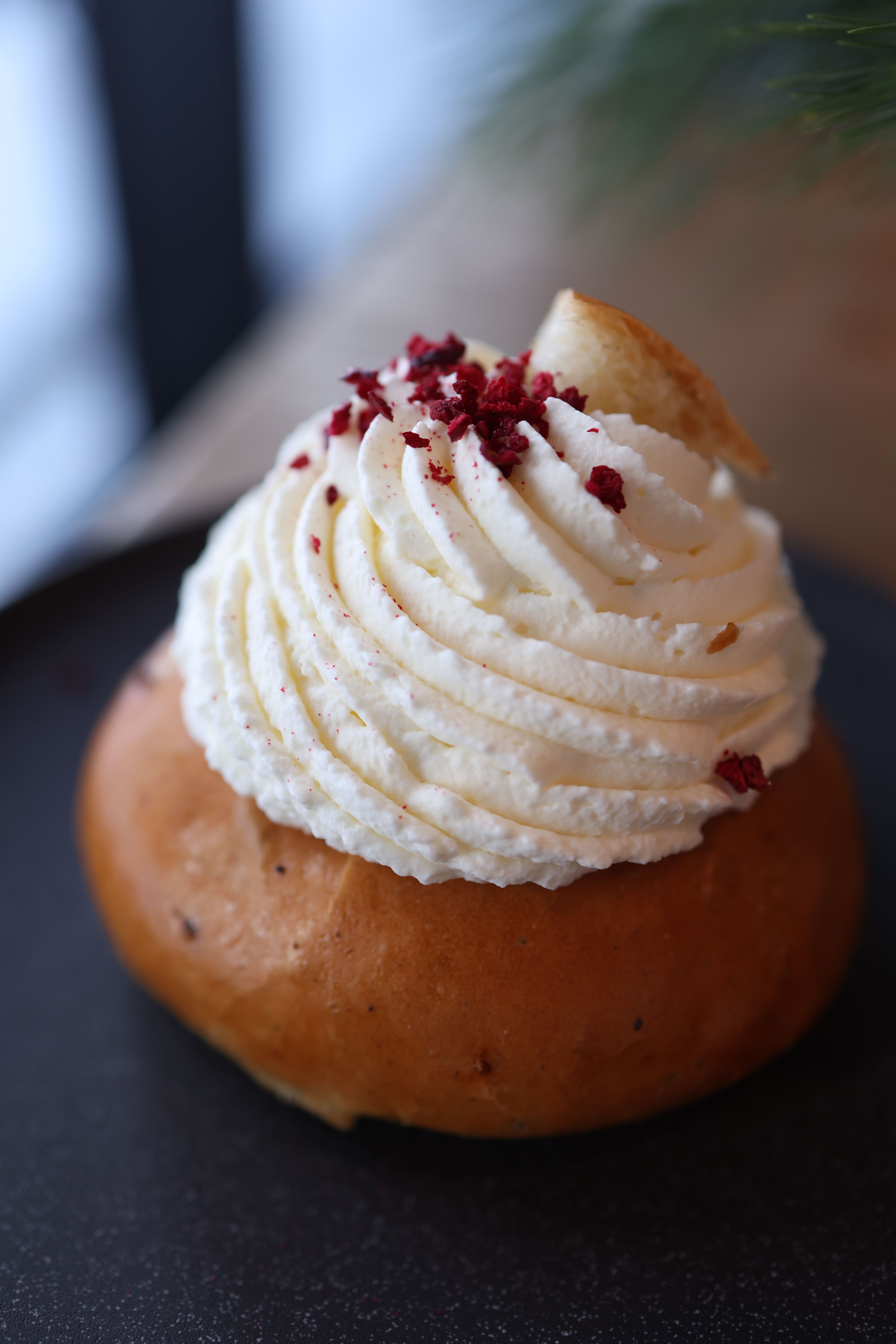 Close-up of a pastry topped with whipped cream and berries, perfect for dessert lovers.