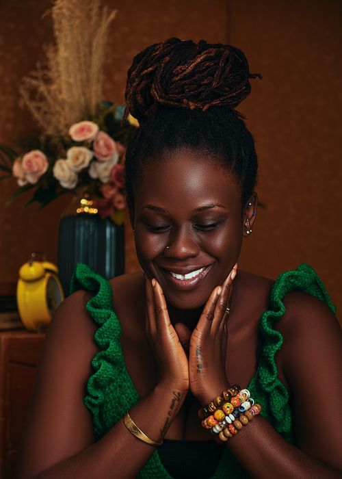 Free Smiling African woman in vibrant studio portrait with beautiful jewelry and floral background. Stock Photo