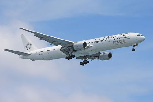 Free Low-angle view of a Singapore Airlines plane flying against a blue sky. Stock Photo