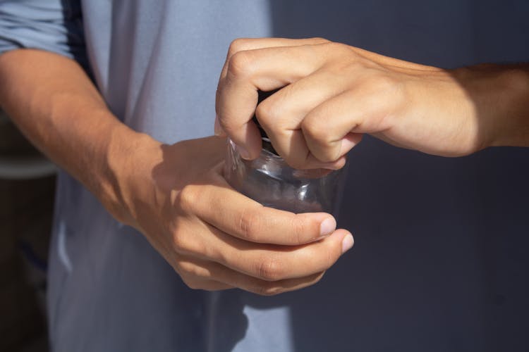 Man In Scrubs Opening A Jar 