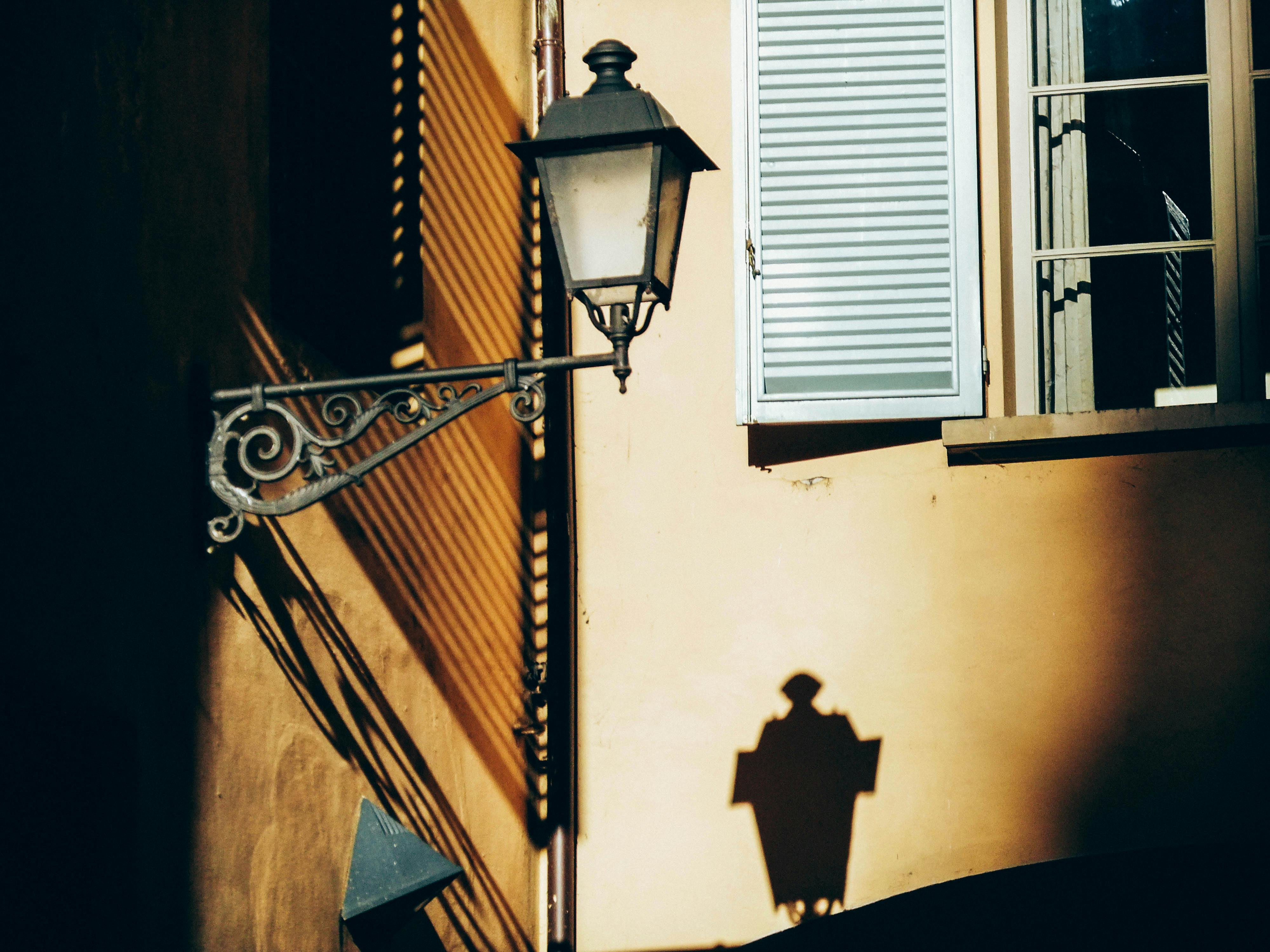 Old Street Light Casting a Shadow on a Nearby Wall