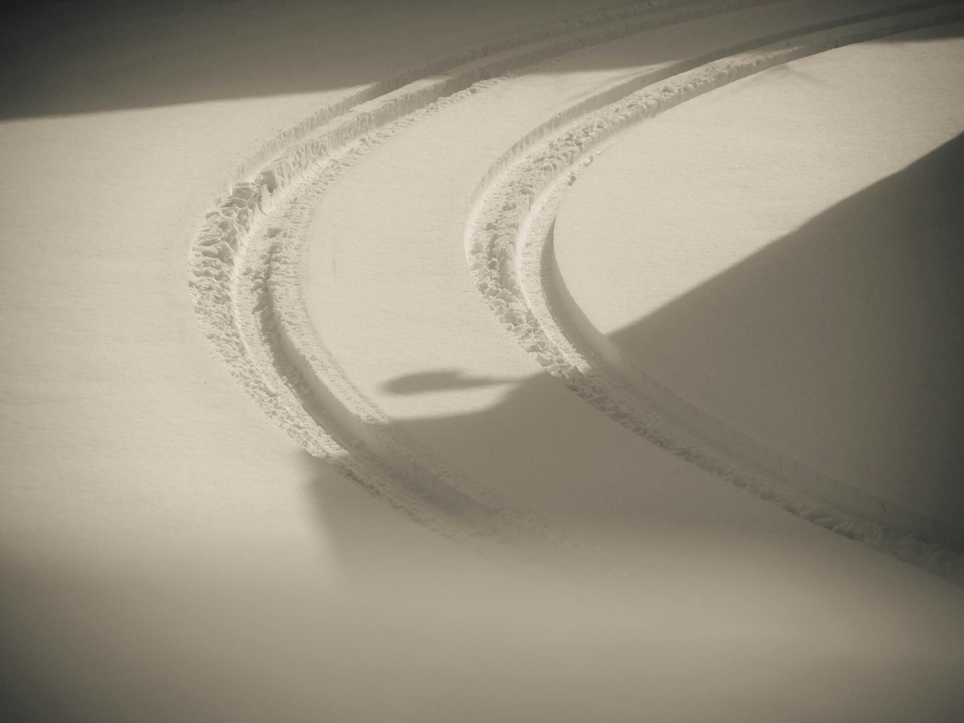 Curved tire tracks on fresh snow in Reggio Emilia, Italy during winter.