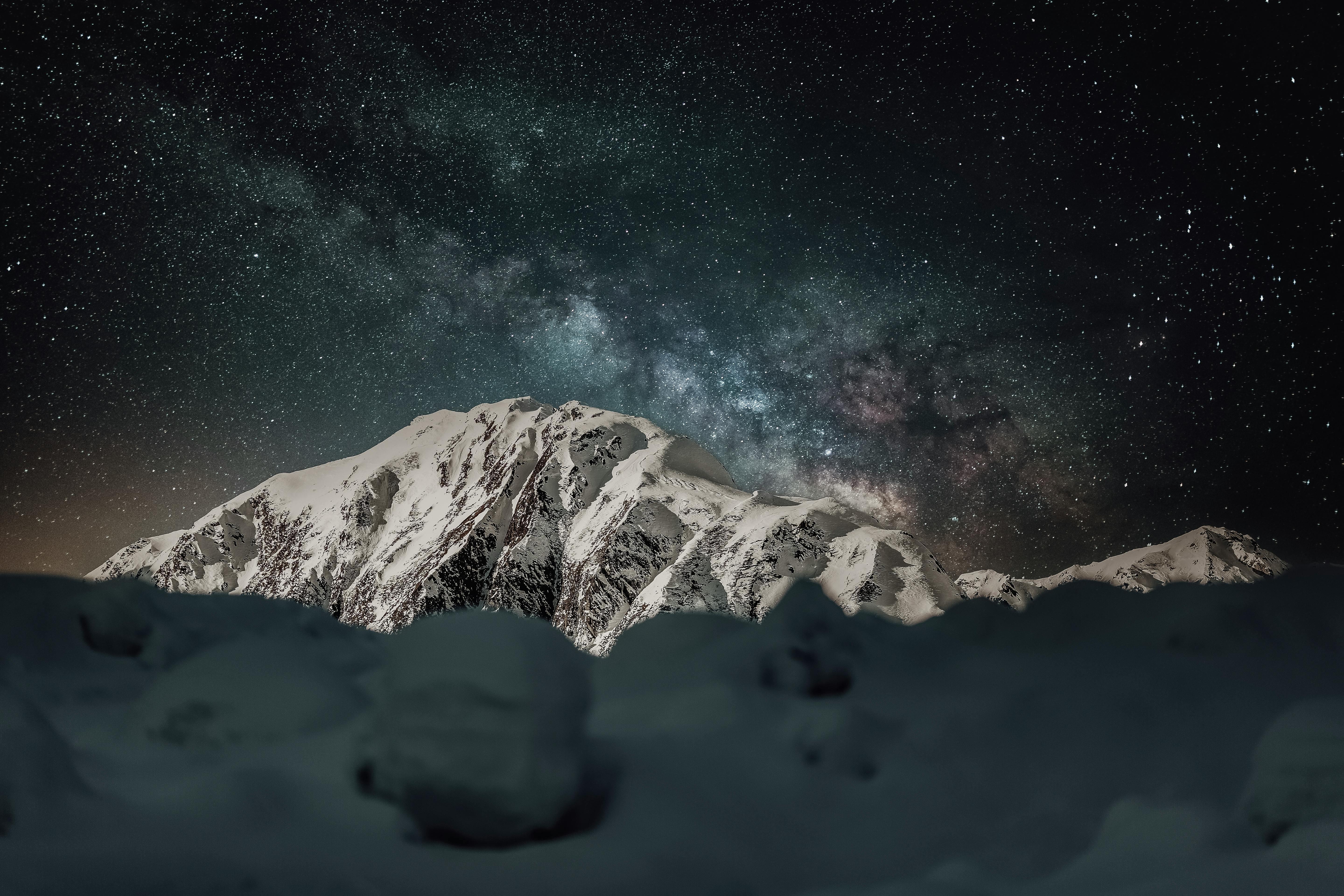 Prescription Goggle Inserts - A stunning view of a snowcapped mountain under a clear, starry night sky with the Milky Way visible.