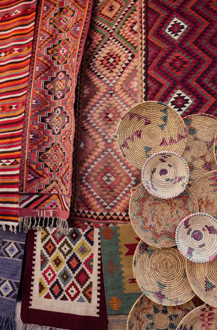 Vibrant collection of handmade textiles and woven baskets, showcasing traditional patterns.