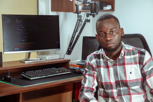 Portrait of a developer coding in a modern office setting, showcasing technology and focus.