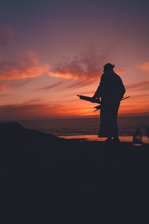 Silhouette of Man in a Mountain Valley During Sunset