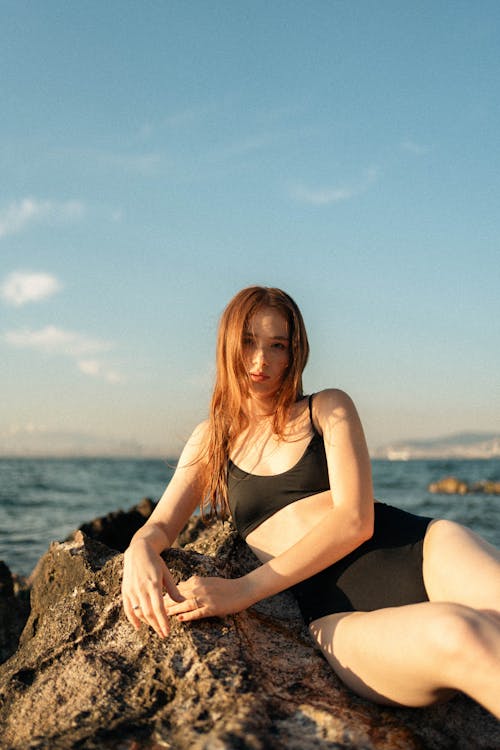 Woman in Bikini Lying Down on Rock on Sea Shore