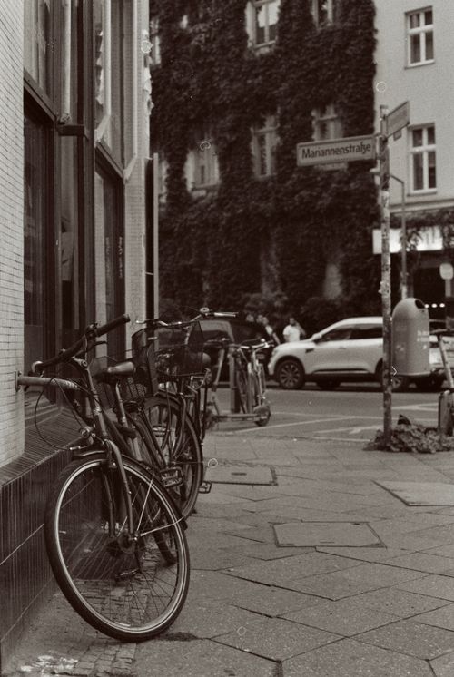 Free Black and white photo of bicycles parked along a city street corner in a bustling urban area. Stock Photo