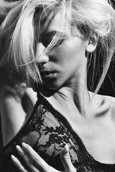 Artistic black and white portrait of a woman in lace lingerie, showcasing elegance and style.