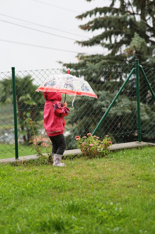 Girl in Jacket and with Umbrella in Garden