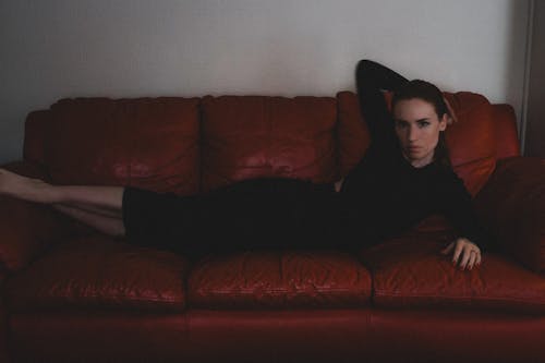 Model Lying Down on Red Couch