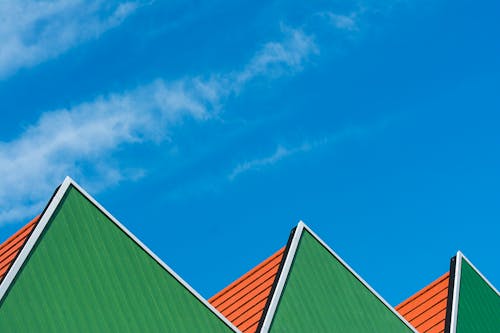 Green, Triangular Tops of Building under Blue Sky