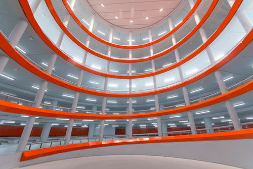 Free Explore the striking modern architecture of a parking garage in Leiden, Netherlands, featuring vibrant red and white design. Stock Photo