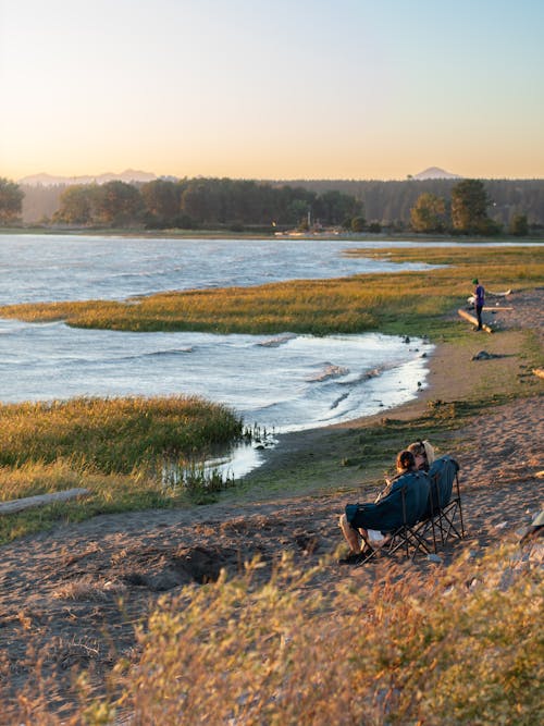 Candid Photo of People Sitting on a Beach 