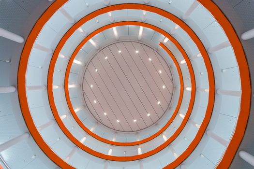 Circular ceiling with spiral design and vibrant lighting in modern building.