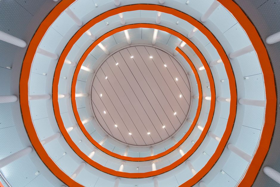 Circular ceiling with spiral design and vibrant lighting in modern building.