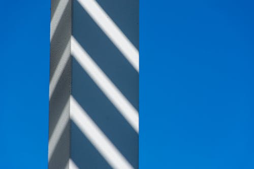 Close-up of a Pillar with Shadows on the Background of Clear, Blue Sky 