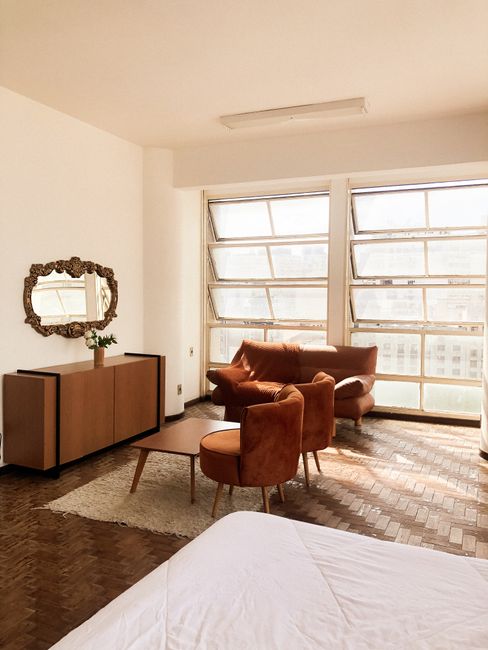 Spacious modern apartment with stylish furniture and sunlight streaming through large windows.
