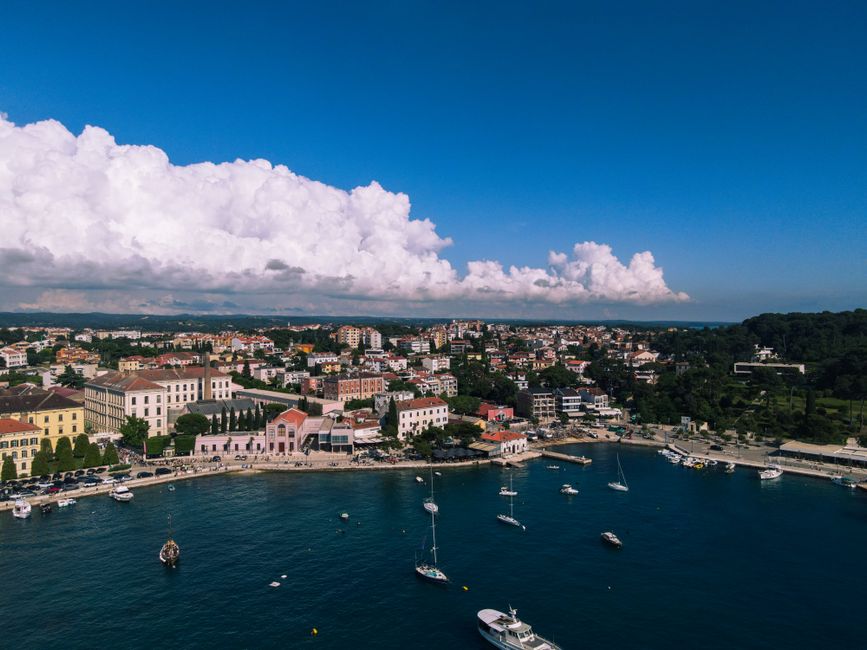 Une vue aérienne vibrante de Rovinj, Croatie, mettant en valeur sa magnifique côte, ses bâtiments colorés et ses bateaux sur la mer Adriatique.