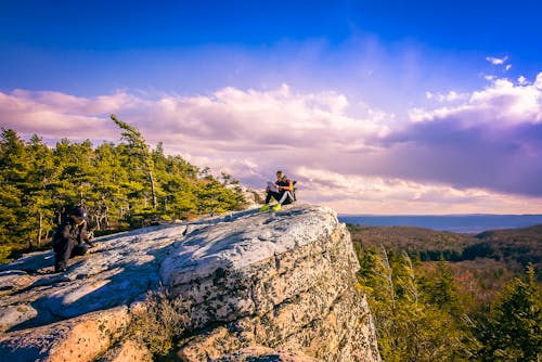 Free Man Sitting on the Edge of Cliff Stock Photo