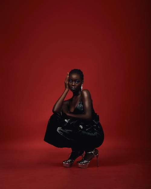 Woman Squatting in Black Dress