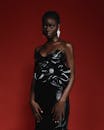 一位非洲女性在时尚拍摄中穿着黑色连衣裙优雅地摆姿势