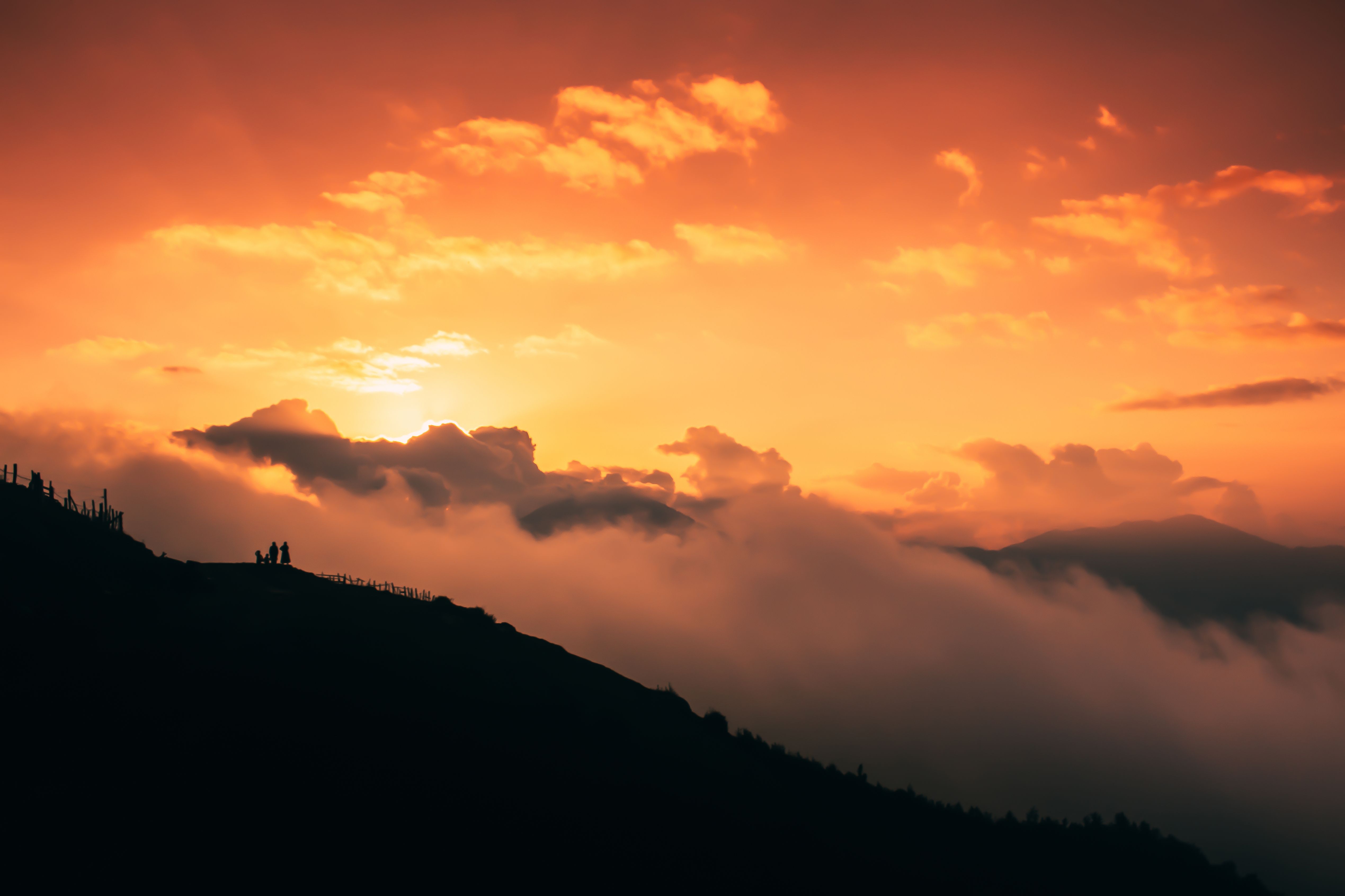 A sunset over a mountain with clouds · Free Stock Photo