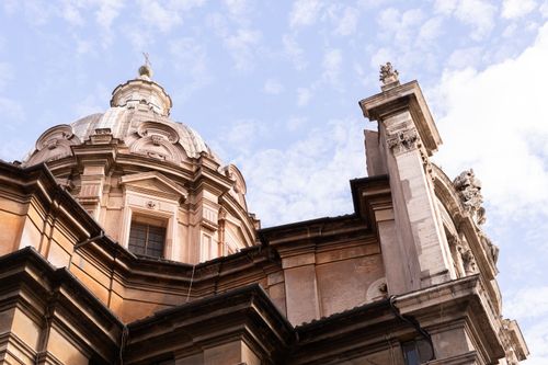Free Close-up of a Baroque dome showcasing Roman architectural elegance against a blue sky. Stock Photo