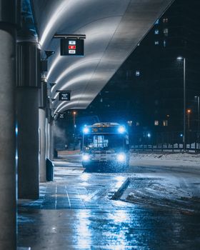 Toronto bus station at night with snow, showcasing urban public transportation in winter.