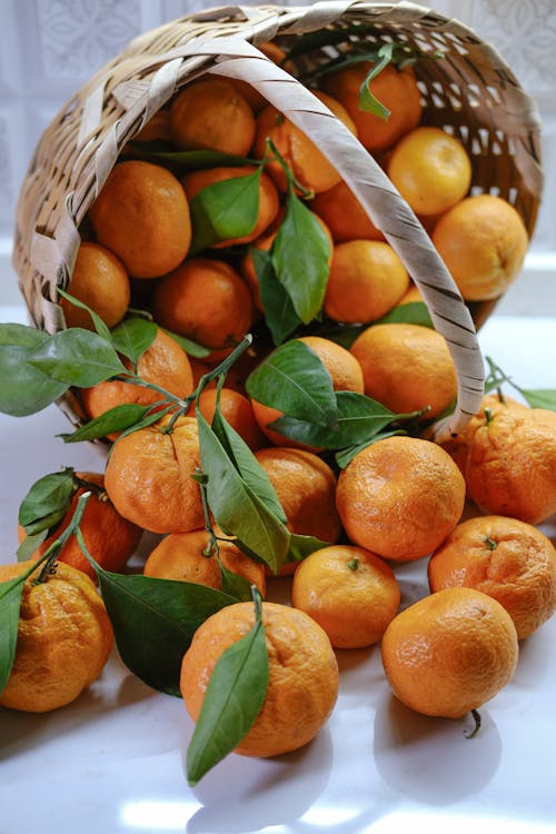 A basket full of oranges with leaves