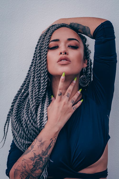 Free Woman Wearing Long-sleeved Crop Top Leaning on Wall Stock Photo