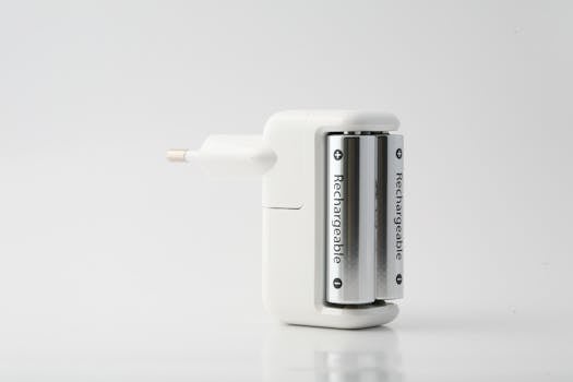 Minimalist shot of a rechargeable battery charger with two batteries on a white backdrop.
