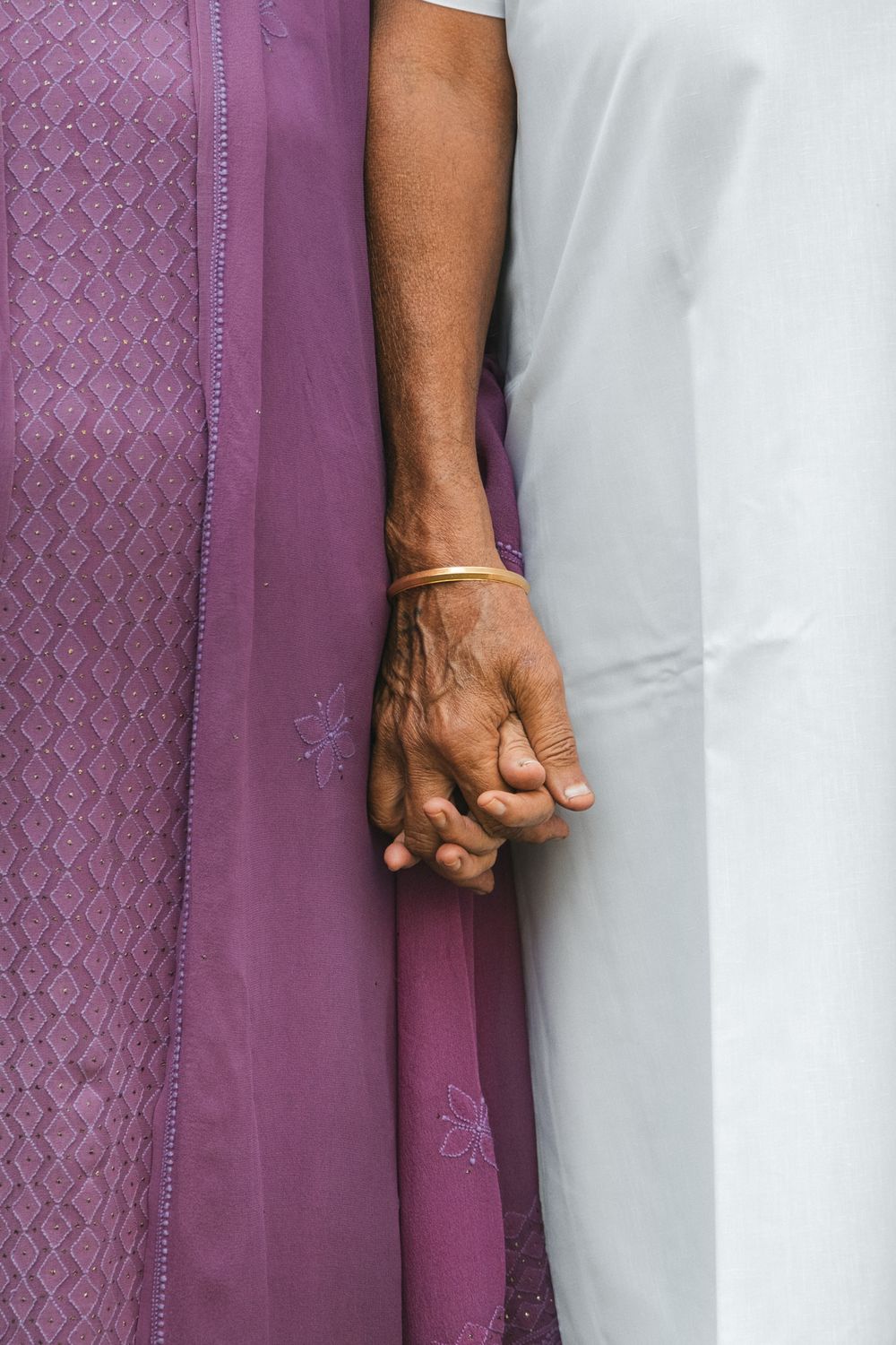 An elderly couple holding hands