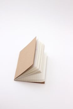 Open brown notebook with grid pages against a white background.