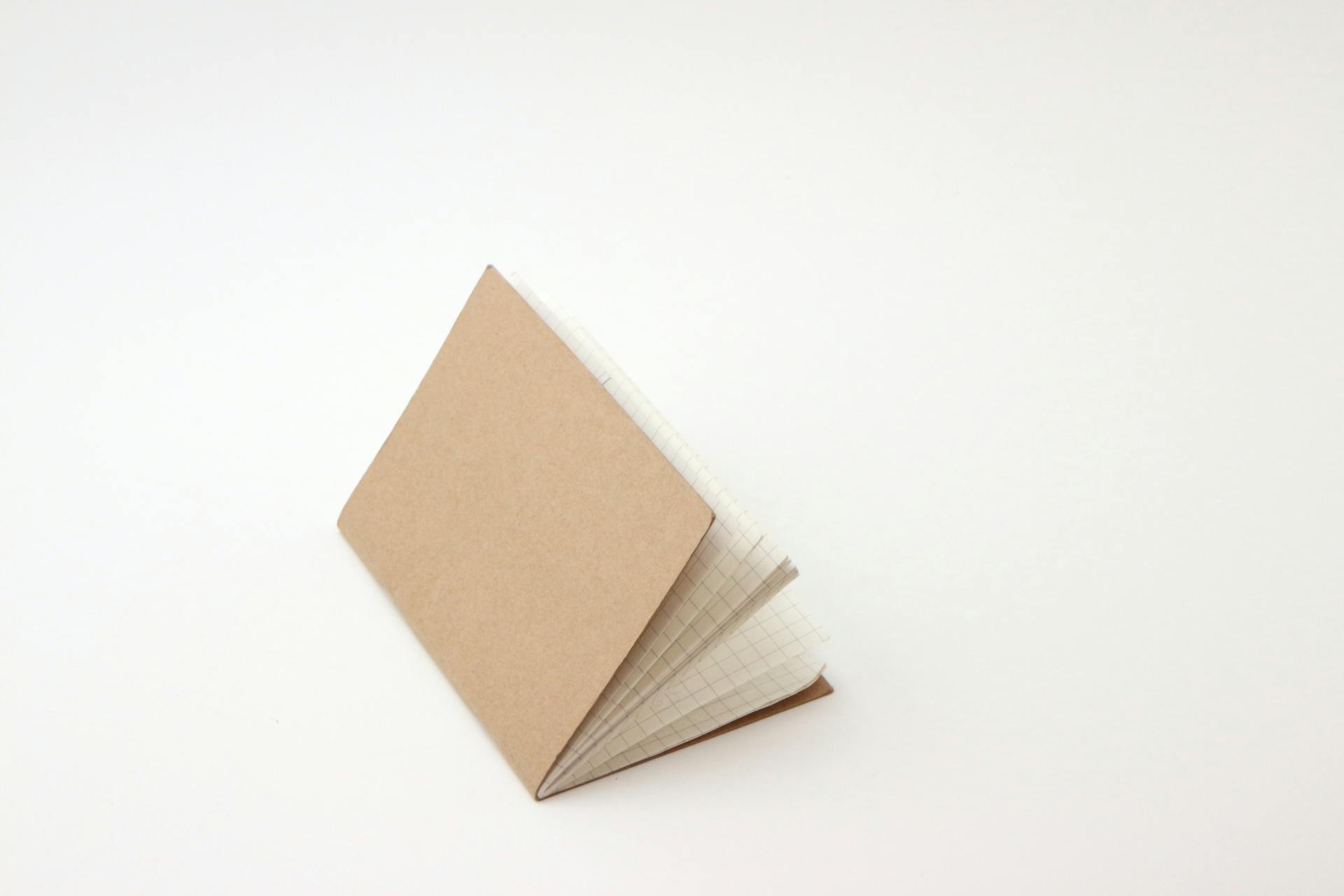 An open notepad with a blank grid design on a simple white background, ideal for design projects.