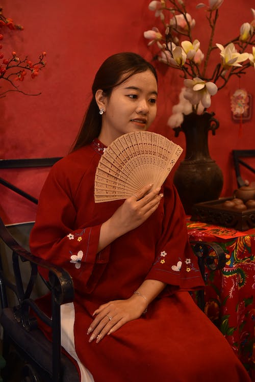 Woman Sitting in Red, Traditional Dress and with Fan