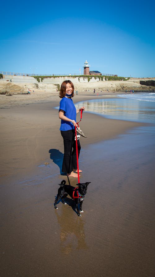 Smiling Woman with Dog on Beach