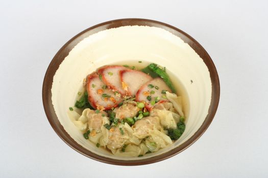 A savory bowl of wonton soup accompanied by sliced pork and fresh greens, perfect for Asian cuisine lovers.