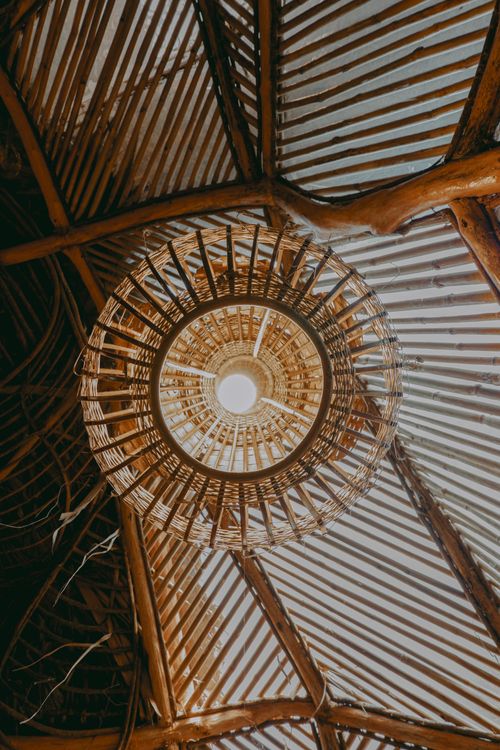 Free Artistic shot featuring a wooden bamboo ceiling lamp with intricate design, creating a warm and rustic ambiance. Stock Photo