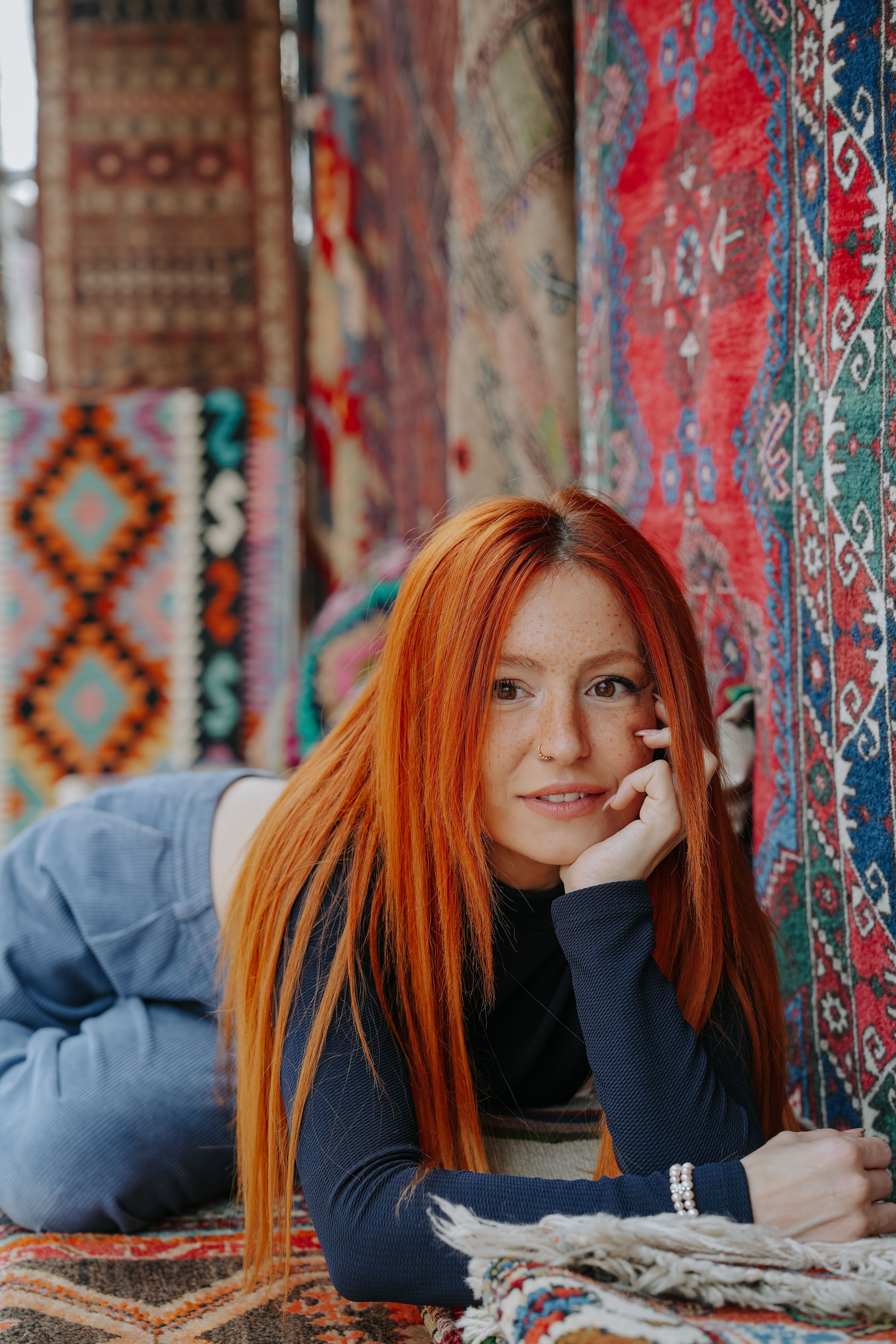Red Haired Woman Laying on a Rug · Free Stock Photo