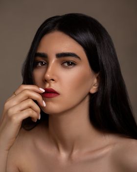 Close-up portrait of a thoughtful woman with long dark hair, showcasing beauty and contemplation.