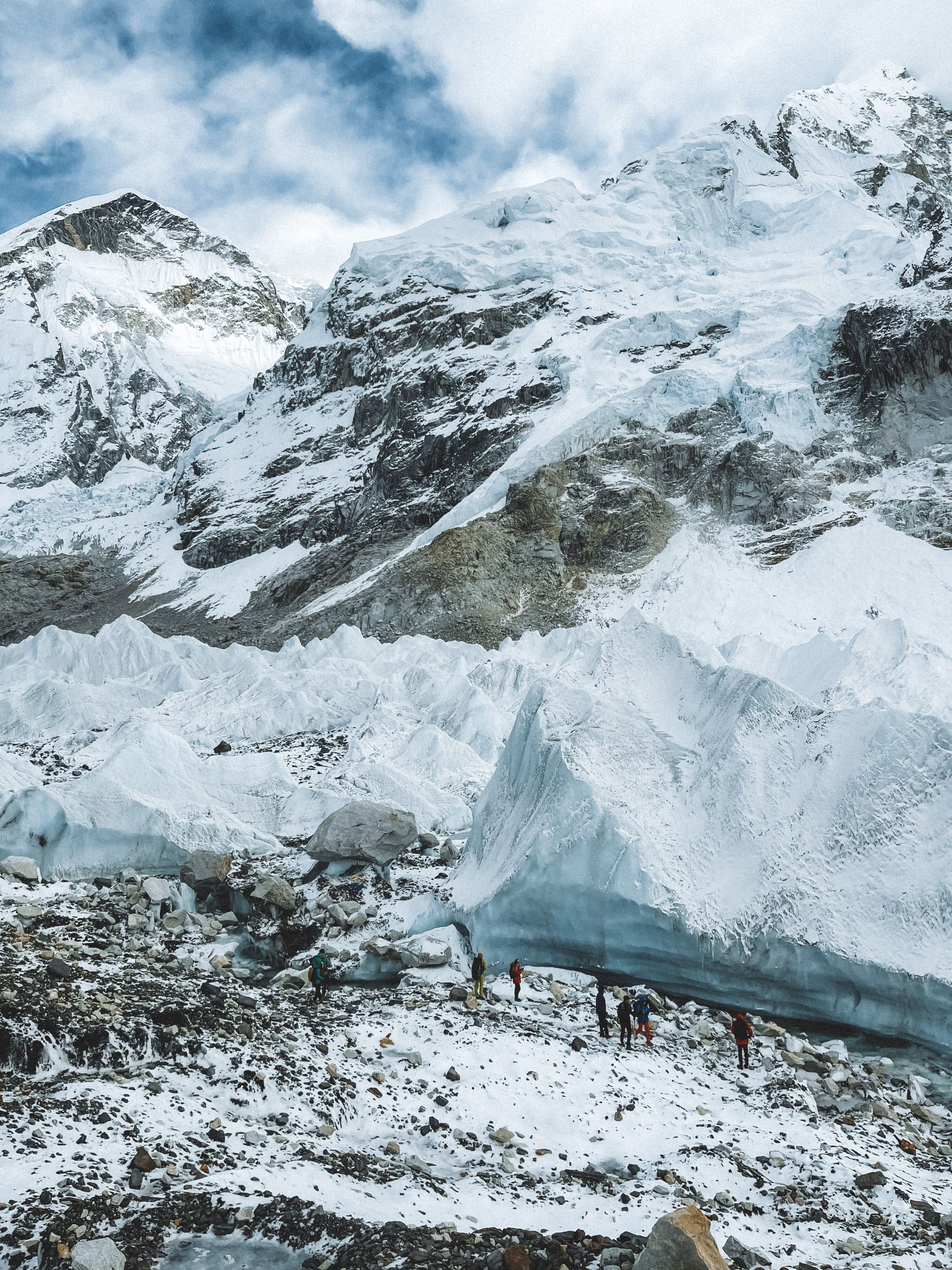 Climbers explore the stunning snowy glaciers in the Himalayas with towering peaks in the background.