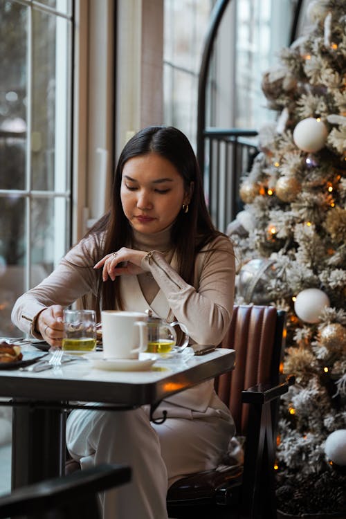 Woman Sitting at Cafe at Christmas