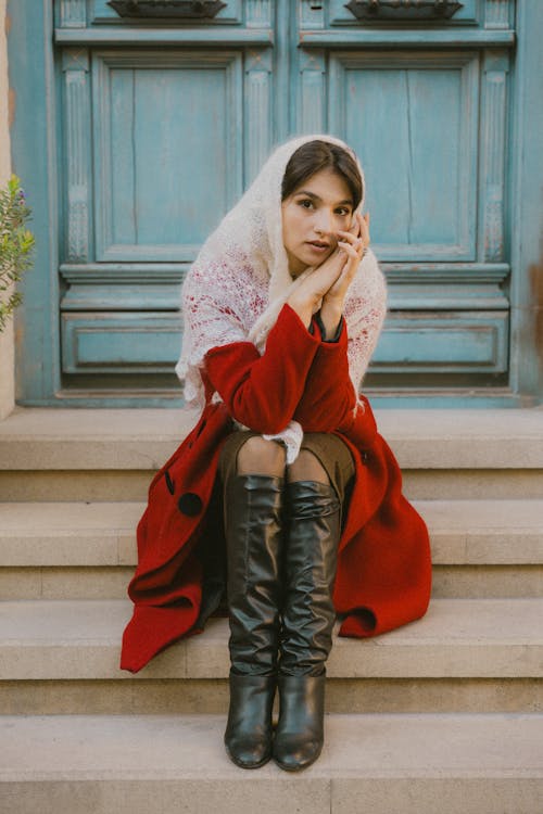 Woman in Shawl and Boots Sitting on Stairs