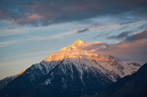 Free Breathtaking view of sunlit snowy mountain peak during sunset in Schenna, Trentino-Südtirol. Stock Photo